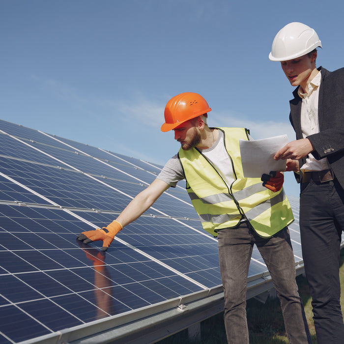 tow person with a paper checking the installed ground solar panels