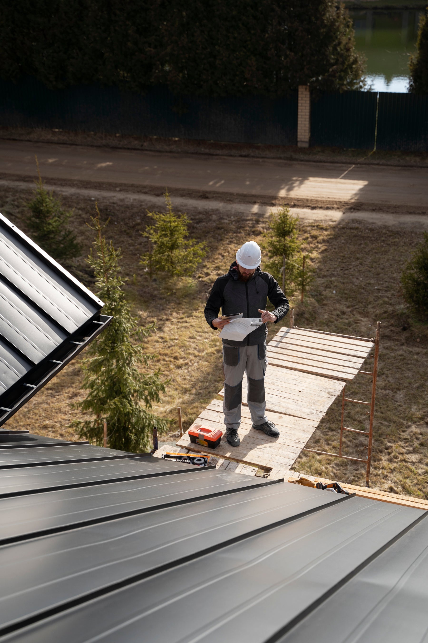 a man with white helmet preparing a roof for solar panel installation
