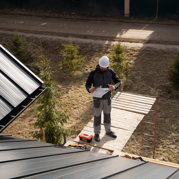 a man with white helmet preparing a roof for solar panel installation