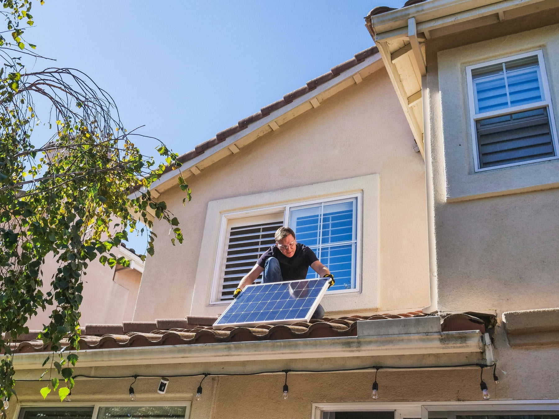 a person at the roof installing a solar panel