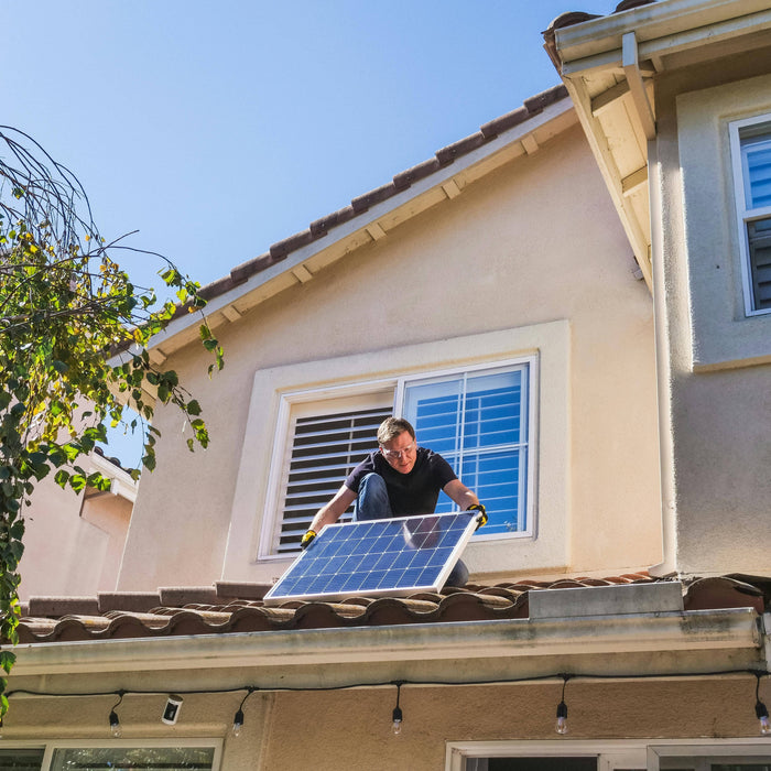 a person at the roof installing a solar panel