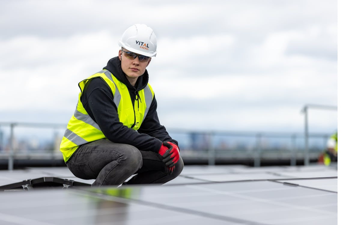 a person sitting in the field of solar panels